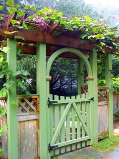 Simple wooden gate painted green with climbing flowers